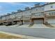 Rear view of townhomes featuring decks and garages at 2689 Richmond Row, Suwanee, GA 30024