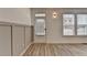 Bright foyer with wood-look flooring, board and batten accent wall, and an entry door with blinds at 2689 Richmond Row, Suwanee, GA 30024