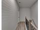 Upstairs hallway with wood-look flooring, white shiplap walls, and a black metal railing at 2689 Richmond Row, Suwanee, GA 30024