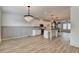 Open-concept kitchen and dining area with white cabinets, a kitchen island, and modern light fixtures at 2689 Richmond Row, Suwanee, GA 30024