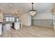 Open-concept kitchen and dining space with modern light fixtures and wood-style flooring at 2689 Richmond Row, Suwanee, GA 30024