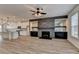 Open-concept living area with fireplace, built-in shelving, and adjacent kitchen at 2689 Richmond Row, Suwanee, GA 30024