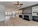 Open concept living area with modern fireplace, stylish kitchen, and wood-look flooring at 2689 Richmond Row, Suwanee, GA 30024