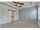 Main bedroom with tray ceiling, ceiling fan, barn door to ensuite, and carpeted floor at 2689 Richmond Row, Suwanee, GA 30024