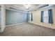 Spacious bedroom with gray carpeting and blue accent wall at 3041 Lexington Ave, Woodstock, GA 30189