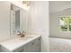 Elegant bathroom featuring gray vanity, white countertop, gold fixtures, and large mirror at 6214 Talmadge Nw Way, Acworth, GA 30101