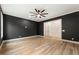 Spacious bedroom with a ceiling fan, dark accent wall, and hardwood floors at 6214 Talmadge Nw Way, Acworth, GA 30101