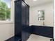 Modern laundry room with navy blue cabinets, gold hardware, and patterned tile floor at 6214 Talmadge Nw Way, Acworth, GA 30101