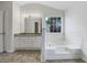 Modern bathroom with granite vanity, soaking tub, and tiled flooring at 1472 Buckingham Pl, Stockbridge, GA 30281