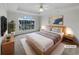 Virtually staged main bedroom with a large window, plush carpeting, and a ceiling fan at 1472 Buckingham Pl, Stockbridge, GA 30281