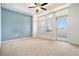 Bedroom with blue accent wall, ceiling fan, carpeted floors, and balcony access at 3334 Peachtree Ne Rd # 908, Atlanta, GA 30326