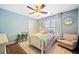 Charming bedroom with blue walls, ceiling fan, a cozy bed and armchair at 8415 River Walk Lndg, Suwanee, GA 30024