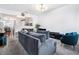 Open living room with a gray sofa, teal accent chair, and a view into the kitchen and dining area at 2804 Parkway Cv, Lithonia, GA 30058