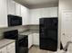 Modern kitchen with black appliances, white cabinets, and dark countertops at 113 Ellis Dr, Conyers, GA 30012