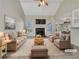 Virtually staged living room featuring a cozy fireplace, vaulted ceiling, and ample natural light at 125 Cedars Glen Cir, Villa Rica, GA 30180
