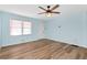 Spacious living room with light blue walls, wood-look vinyl flooring, and a ceiling fan at 4251 Hamilton Mill Rd, Buford, GA 30519