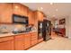 Kitchen with black appliances, wood cabinetry, and tile floors at 5315 Birchland Ct, Buford, GA 30518