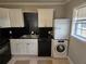 Compact kitchen featuring black countertops, white cabinets, and black appliances at 149 Bixby Se Ter, Atlanta, GA 30317
