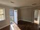 Living room with hardwood floors, white trim, and an entryway with a security door at 149 Bixby Se Ter, Atlanta, GA 30317