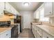 Galley kitchen with white cabinets, black appliances, and light countertops at 6226 Pine Ln, Douglasville, GA 30135