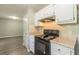 Modern kitchen with white cabinets, granite countertops, and black appliances at 6226 Pine Ln, Douglasville, GA 30135