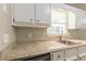 Clean kitchen with granite counters, white cabinets, and stainless steel sink at 6226 Pine Ln, Douglasville, GA 30135