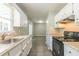 Open kitchen with white cabinetry, granite countertops, and black appliances at 6226 Pine Ln, Douglasville, GA 30135