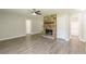 Living room with a stone fireplace, wood-look flooring, and access to another room at 6226 Pine Ln, Douglasville, GA 30135