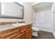 Clean bathroom with wood vanity, shower/tub combo, and dark flooring at 8661 Chestnut Ln, Lithia Springs, GA 30122
