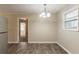 Simple dining room with wood-look flooring and a chandelier at 8661 Chestnut Ln, Lithia Springs, GA 30122