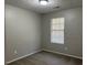 Empty bedroom with neutral gray walls, carpeted flooring, and window at 1654 Tree Line Rd, Lithonia, GA 30058