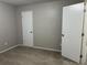 Empty bedroom with two white doors and neutral gray walls at 1654 Tree Line Rd, Lithonia, GA 30058
