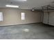 Empty one-car garage with gray floor and beige walls at 1654 Tree Line Rd, Lithonia, GA 30058