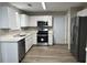 Updated kitchen with white cabinets, stainless steel appliances, and wood-look flooring at 1654 Tree Line Rd, Lithonia, GA 30058