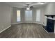 Spacious living room with wood-look floors, black fireplace, and ceiling fan at 1654 Tree Line Rd, Lithonia, GA 30058