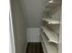 Empty pantry with white shelves and wood-look flooring at 1654 Tree Line Rd, Lithonia, GA 30058