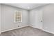 Empty bedroom with gray carpeting, a single window, and a white door at 2590 Rolling View Se Dr, Smyrna, GA 30080