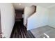 Open entryway with dark wood-look flooring, gray carpet, and a staircase at 7709 Sudbury Cir, Covington, GA 30014