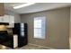 Kitchen with white cabinets, black appliances, and a window at 6268 Marbut Farms Trl, Lithonia, GA 30058