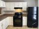 Modern kitchen features black appliances and white cabinets at 6268 Marbut Farms Trl, Lithonia, GA 30058
