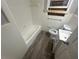 Clean bathroom featuring a bathtub, toilet, and vanity with wood-look floor at 4887 Glenwood Rd, Decatur, GA 30035