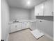 Bright laundry room featuring white cabinets and a utility sink at 422 Mcdaniel Pl, Canton, GA 30115