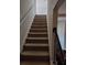 Carpeted staircase with dark wood railing at 2513 Colin Pl, Mcdonough, GA 30253