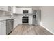 Modern kitchen featuring white cabinets, stainless steel appliances, and light wood flooring at 100 Spicewood Ct, South Fulton, GA 30349