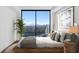 Spacious bedroom with large windows offering city views and a wooden platform bed at 2425 Peachtree Ne Rd # 1106, Atlanta, GA 30305