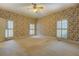 Bright bedroom featuring floral wallpaper, carpet, and plantation shutters at 1216 Valley Dr, Conyers, GA 30012
