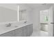 Double vanity bathroom with marble floors and gray cabinets at 3328 Pepperpike Ct, Loganville, GA 30052