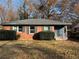 Brick ranch home with dark shutters, landscaping, and a spacious yard at 721 Yale Sw Pl, Atlanta, GA 30315