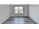 Bright bedroom with grey wood-look flooring and large windows at 123 Maison Nw, Atlanta, GA 30327