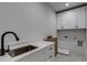 Laundry room with white cabinets and a stainless steel sink at 1258 Prospect Rd, Lawrenceville, GA 30043